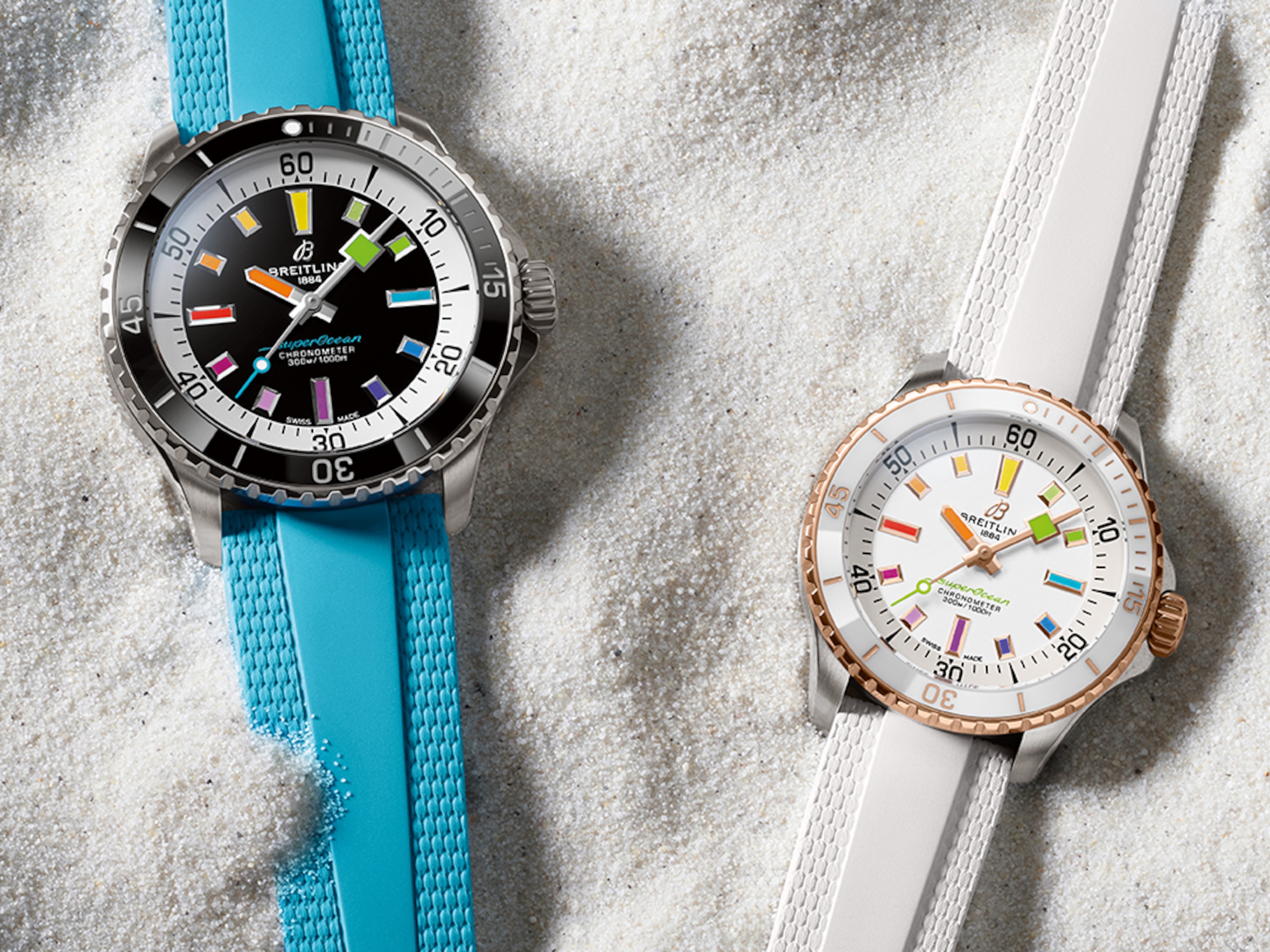 兩枚Superocean自動腕錶,一枚配綠松石色錶帶,另一枚配白色錶帶,躺在沙灘上。